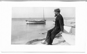 Captain Thomas Sandsbury near the shore with his boat, Tuckernuck Island, Mass., undated