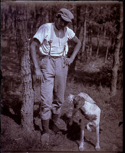 Man with a dog standing in the woods, Mashpee, Mass.