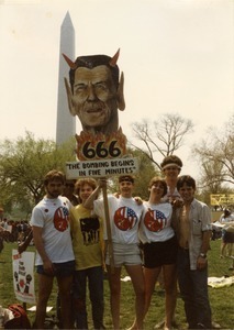 UMass Peacemakers contingent at the 'Four Days in April' demonstration in Washington D.C., holding image of Ronald Reagan with devil's horns and caption '666 The bombing begins in five minutes'