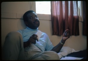 Rev. Ralph Abernathy seated on a hotel room bed