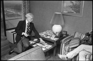 Andy Warhol sorting through photographs during a reception at the Birmingham Museum of Art