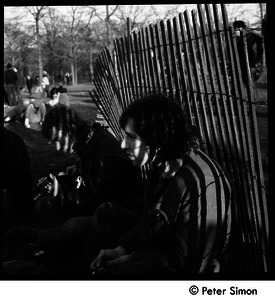 Young people seated by a fence at the Be-In, Central Park, New York City