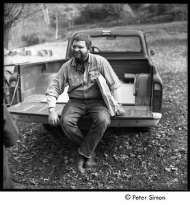 Doug Parker seated in the back of a pickup truck, Tree Frog Farm Commune