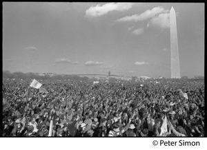Massive crowd raising hands in peace symbols, with Washington Monument in background: Vietnam Moratorium march on Washington