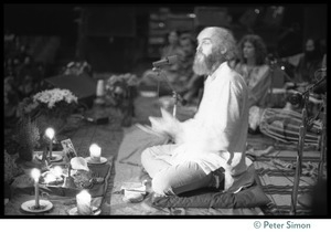 Ram Dass seated onstage at the Winterland Ballroom during his 'marathon'