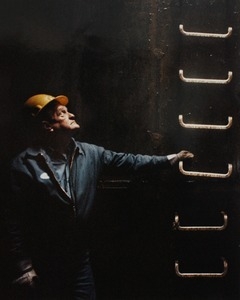 John Barlow, a Narragansett Bay Commission worker, in a sewer at Ernest Street, Providence, looks up to the manhole opening as fellow workers talk to him