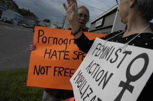 Protest against a pornographic video store in Northampton: protesters holding sign reading 'Pornography is hate speech, not free speech' and 'Feminist Action Mobilization'