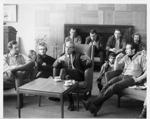 John W. Lederle seated indoors speaking with a group of students in Colonial Lounge, Student Union