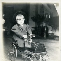Young boy in a toy car