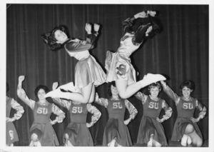 Suffolk University basketball cheerleaders in mid air, 1965