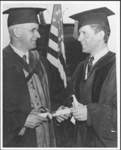 Suffolk University President Gleason L. Archer (1906-1948) presenting degree to student at commencement, circa 1950s