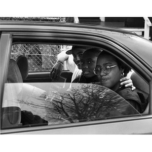 Portrait of three teenagers sitting in the backseat of a car.