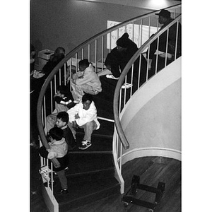 Teens and children sitting on the spiral staircase at the Jorge Hernandez Cultural Center.