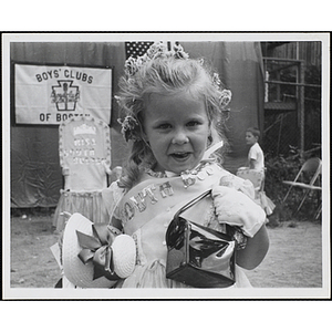 Boys' Club Little Sister Contest winner holding a purse and a doll