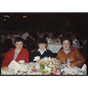 Three boys posing for the camera while seated at the "Recognition Dinner at Harvard Club"