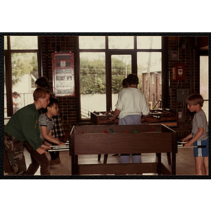 Three boys play foosball