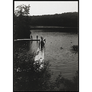 A swimming supervisor watches children on a dock