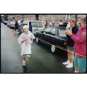 A boy runs past spectators during the Battle of Bunker Hill Road Race