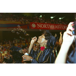 Student blowing bubbles at commencement