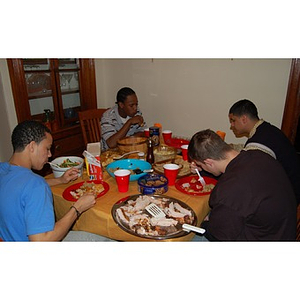 Four students eat at the Torch Scholars Thanksgiving Dinner