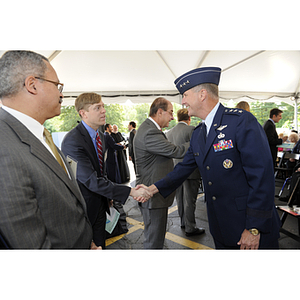 Lieutenant General Ted F. Bowlds shakes hands with a guest at the groundbreaking ceremony for the George J. Kostas Research Institute for Homeland Security, located on the Burlington campus of Northeastern University
