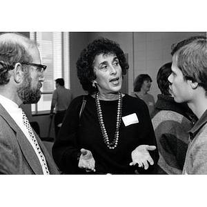 A woman speaking with two men at the Law School Open House, 1985