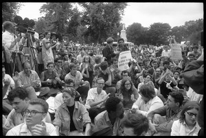 Anti-Vietnam war protesters sitting down after Assembly of Unrepresented People peace march, raising signs 'Refuse to serve in the armed forces'