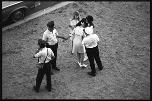 Police assisting an overwrought Beatles fan before the concert at D.C. Stadium
