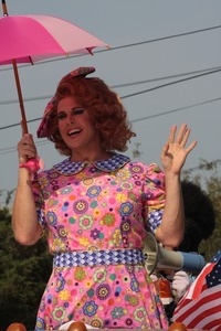 Parade marcher in pink flowered dress with pink umbrella : Provincetown Carnival parade