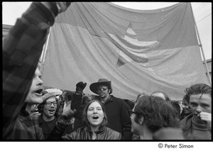 MIT war research demonstration: demonstrators raising their fists in front of the NLF flag