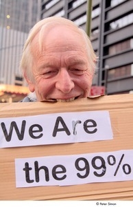 Occupy Wall Street: demonstrator biting cardboard sign reading, 'we are the 99 percent'