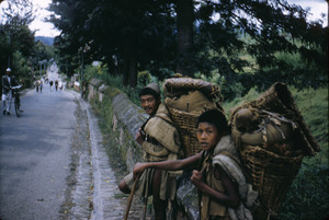 Porters rest while carrying goods to market