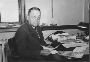 Harold M. Gore sitting indoors, behind desk