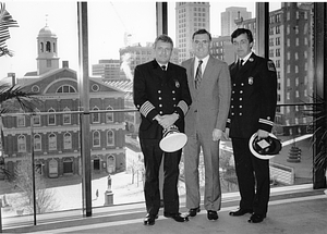 Mayor Raymond L. Flynn posing in his office with Boston Deputy Fire Commissioner Leo D. Stapleton and another unidentified Boston Fire captain