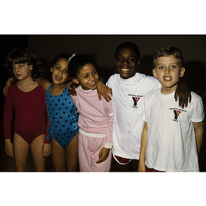 Young children, some wearing Central Branch YMCA shirts, smiling for a group photograph