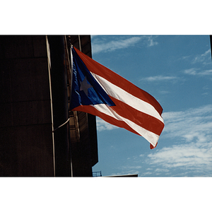 The Puerto Rican flag flies next to a building