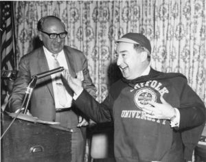 Massachusetts politician John E. Powers receives a Suffolk University beanie and sweatshirt at a university event