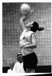 A Suffolk University women's volleyball player spikes the ball, circa 2000