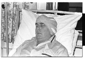 Eddie McGrady, SDLP politician, pictured candidly in a hospital bed wearing a bandage on his head