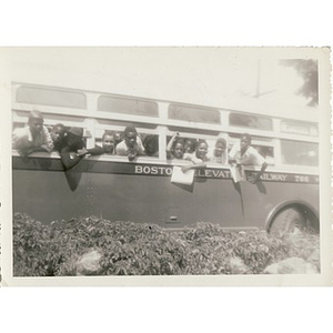 A group of boys hang out the window of a bus on the way to Breezy Meadows Camp