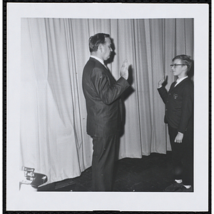 An unidentified man presents an oath to a boy at a Boys' Club of Boston St. Patrick's Day inaugural ball and exercises event