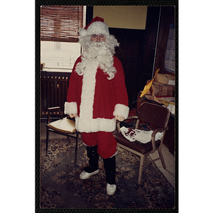 Santa Claus poses in front of two chairs