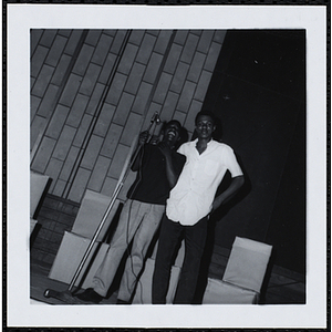 Two young men standing at the microphone during a Boys' Club Little Sister Contest