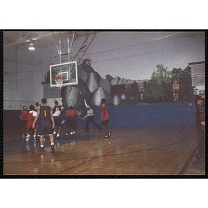 A referee makes a call as the ball falls into the basket during a basketball game