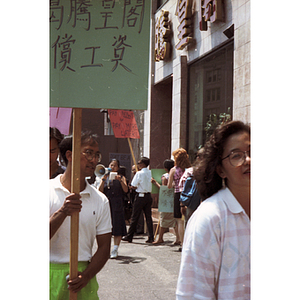 Demonstrators hold protest signs picketing for back wages outside of Dynasty Restaurant