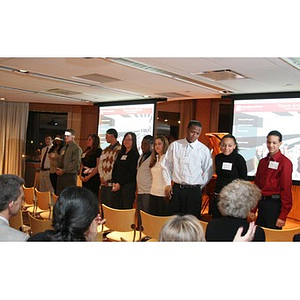 The Torch Scholars stand in front of the room at an event