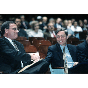 Comptroller Bill Kneeland and President Richard Freeland shake hands in the audience at a General University Meeting