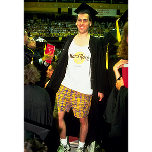 A student modeling his shorts and a Hard Rock Cafe T-shirt under his gown during the commencement ceremony