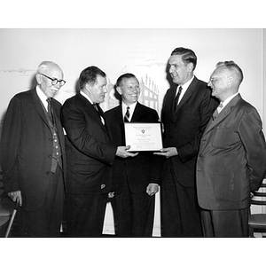 Five men pose together with an award at a Law School Alumni annual awards dinner