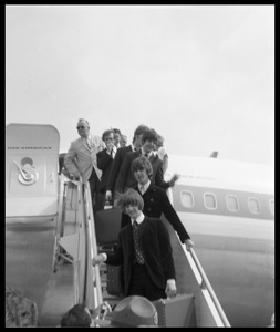 Ringo Starr, George Harrison, and Paul McCartney descending the ramp from a Pan American airways Boeing 707 (John Lennon barely visible behind McCartney)